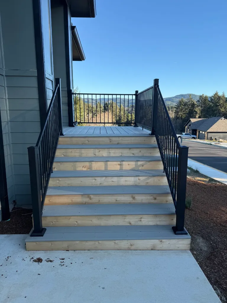 Custom deck stairs with black metal baluster railings and cedar risers